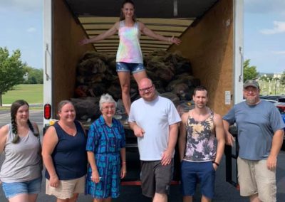 Volunteers help load the truck with bags of donated shoes